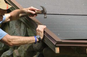 A homeowner reviews roofing paperwork with a contractor on the front porch of a two-story house.